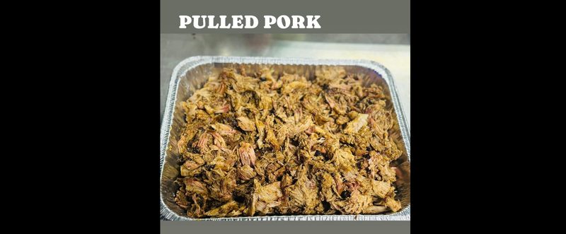 Pulled pork in a foil pan beneath the venue’s "Pulled Pork" banner at Shiloh’s Lounge