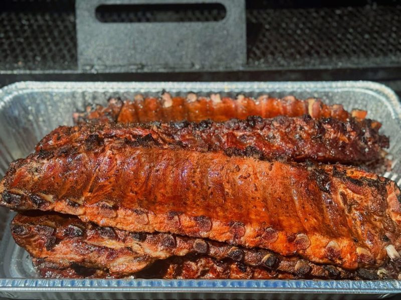 Smoked baby back ribs in a foil pan at Shiloh’s Lounge
