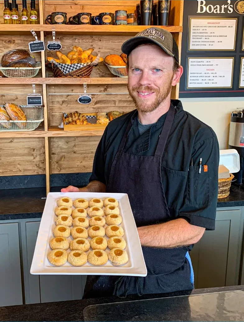 Niko’s co-owner Matt Weafer holding a tray of fresh thumbprint cookies